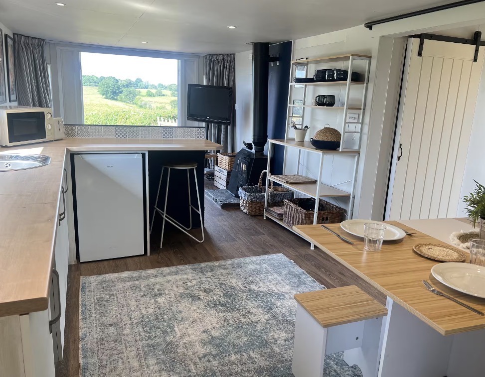 Holiday-let kitchen and dining area with white cabinetry