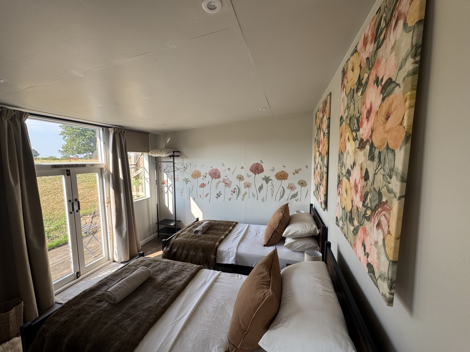Twin guest bedroom with light painted walls and floral details