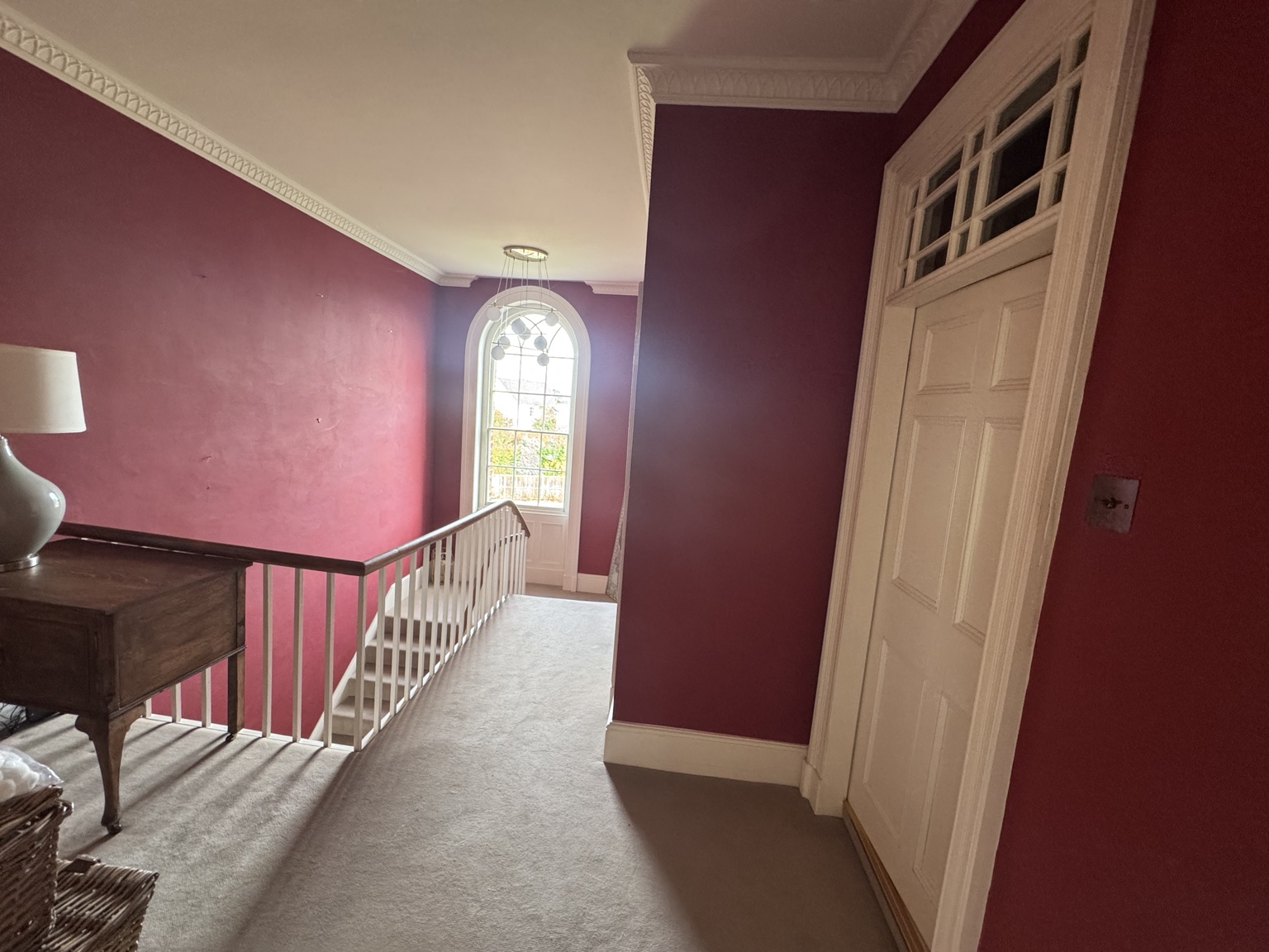 Upper landing before, with red walls and arched window